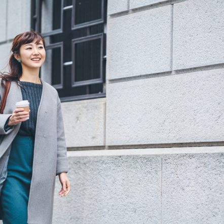business woman walking by an office building