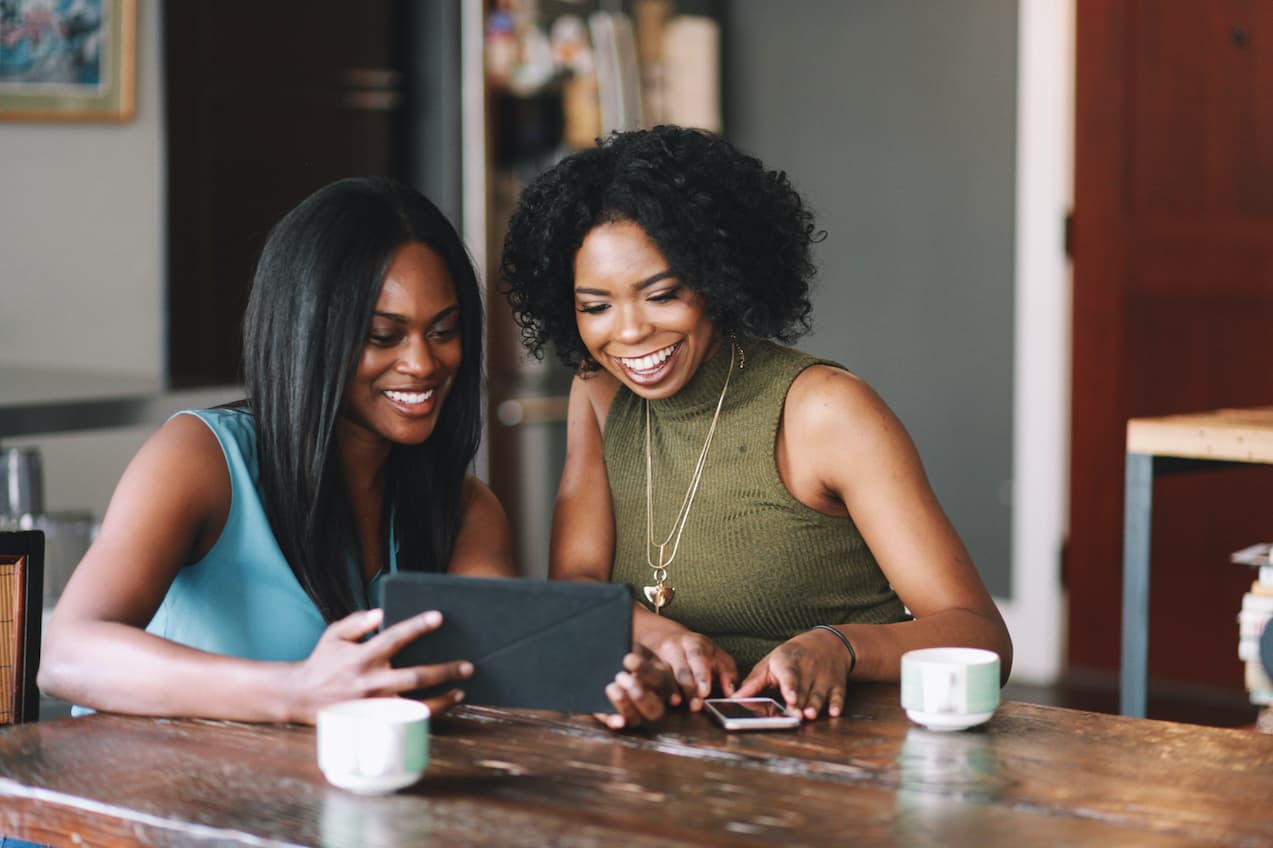 Happy women looking at their tablet