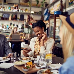 Happy woman leaving a review at a cafe