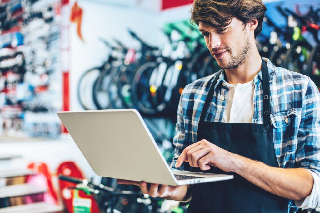 Bike shop owner buying domains on his laptop