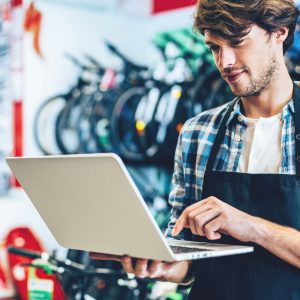 Bike shop owner buying domains on his laptop